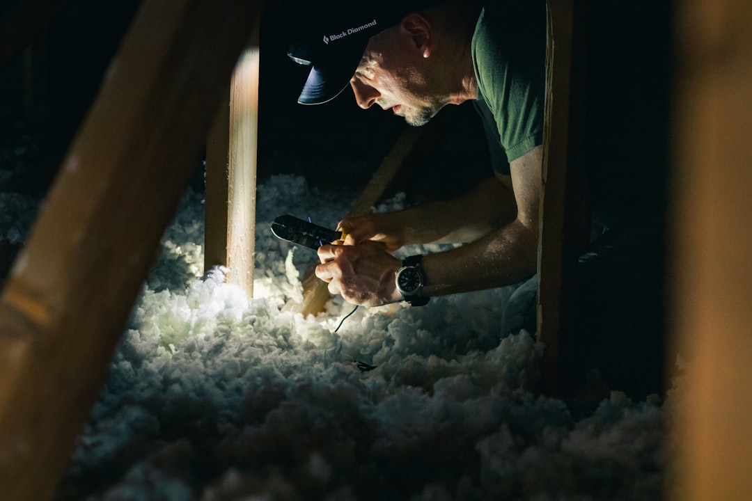 Worker installing insulation in a home attic
